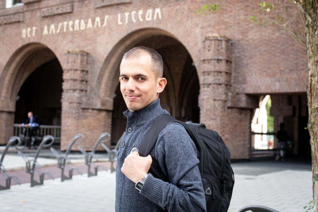 Student met rugzak voor het Amsterdams lyceum